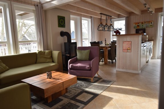 Gemütliches Wohnzimmer mit Sofa, Sessel und Essbereich in einem hellen Raum.