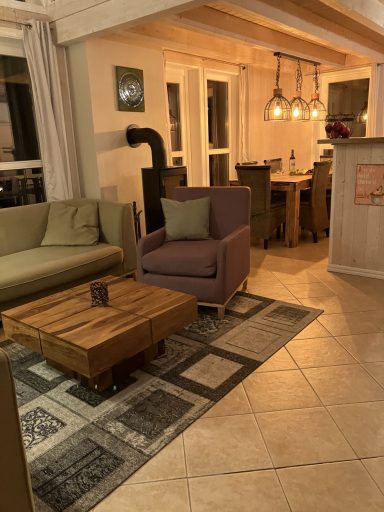 Wohnzimmer mit modernen Möbeln, einem Couchtisch und warmem Licht von Pendelleuchten.