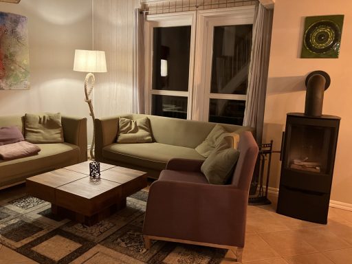 Gemütlicher Wohnbereich mit Couch, Lampe, Tisch und einem Kamin.