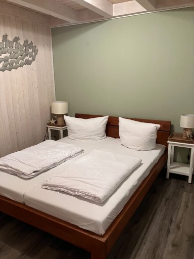 Helles Schlafzimmer mit einem Doppelbett, Nachttischen und Lampen.